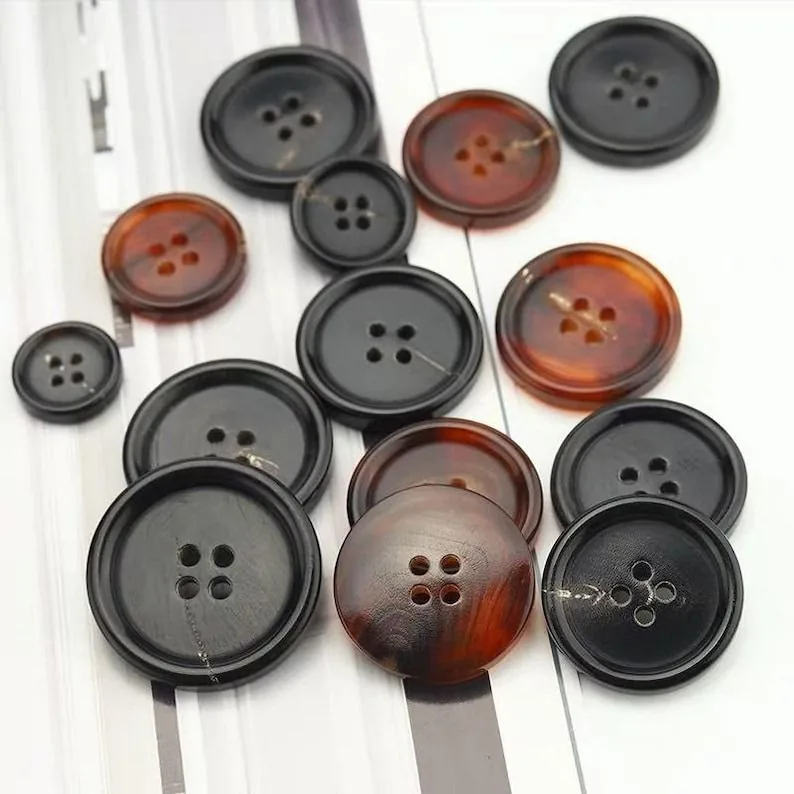 Polished horn buttons in black and amber tortoise tones, in assorted sizes
